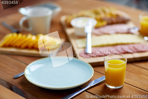 Image of plate and glass of orange juice on table with food