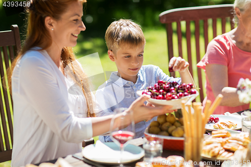 Image of happy family having dinner or summer garden party