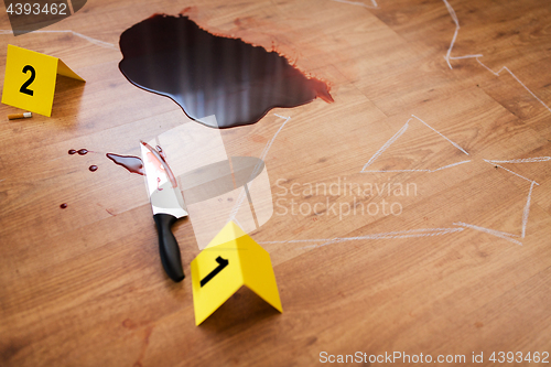 Image of chalk outline and knife in blood at crime scene