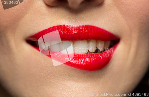 Image of close up of woman with red lipstick biting lip