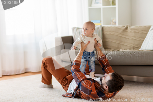 Image of happy father with little baby boy at home