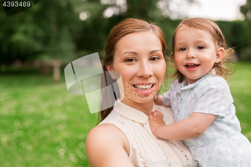 Image of mother with baby girl taking selfie at summer park