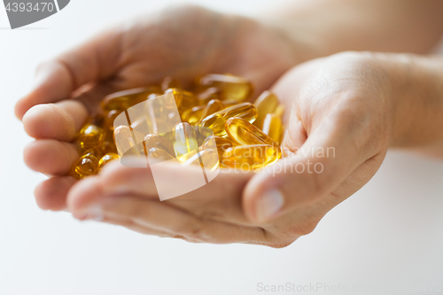 Image of hands holding cod liver oil capsules