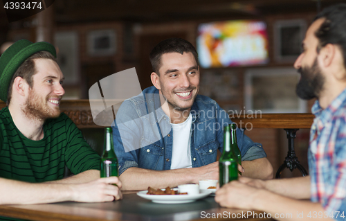 Image of happy male friends drinking beer at bar or pub