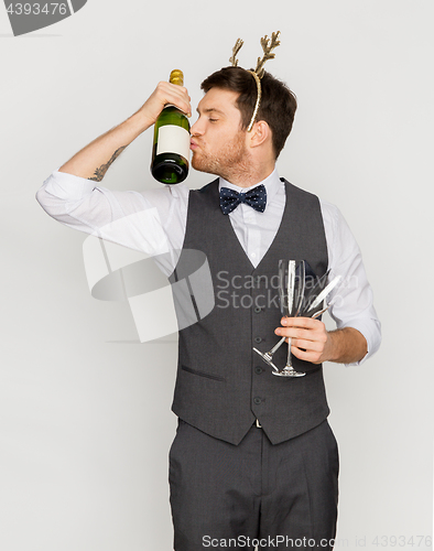 Image of man kissing bottle of champagne at christmas party
