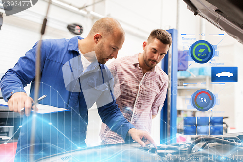 Image of auto mechanic with clipboard and man at car shop