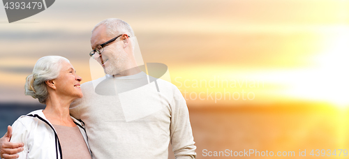 Image of happy senior couple over sunset background