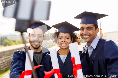 Image of students or graduates with diplomas taking selfie