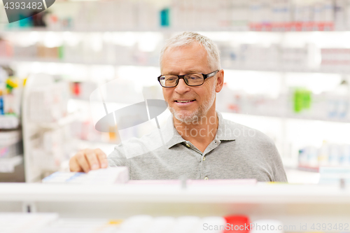 Image of senior male customer with drug at pharmacy