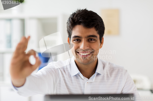 Image of businessman showing ok hand sign at office