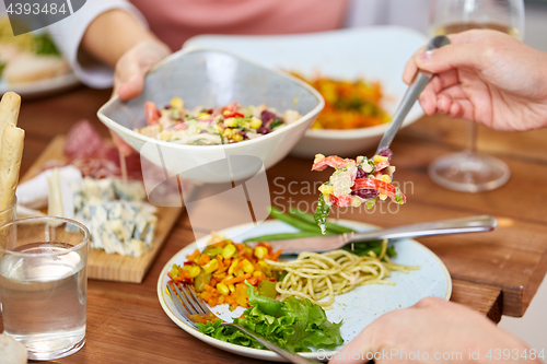 Image of people eating salad at table with food