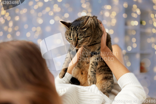 Image of young woman with cat lying in bed at home