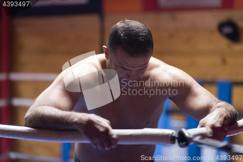 Image of kick boxer resting on the ropes in the corner