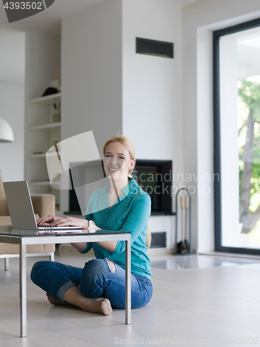 Image of young women using laptop computer on the floor