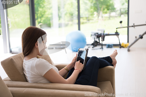 Image of woman sitting on sofa with tablet computer