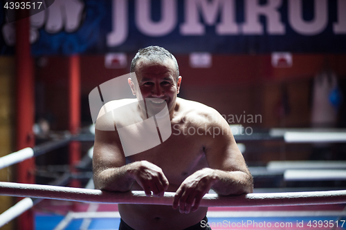 Image of kick boxer resting on the ropes in the corner