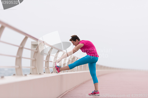 Image of woman stretching and warming up on the promenade