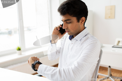 Image of businessman calling on smartphone at office