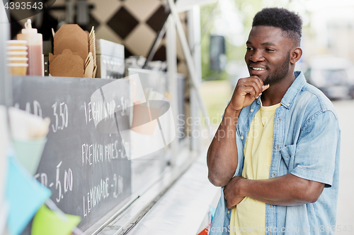 Image of male customer looking at billboard at food truck