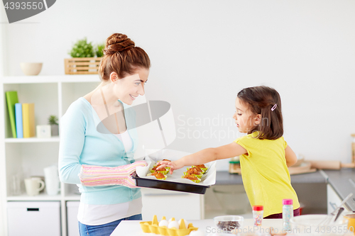 Image of mother and daughter baking muffins at home