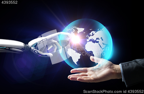 Image of human and robot hand with virtual earth hologram