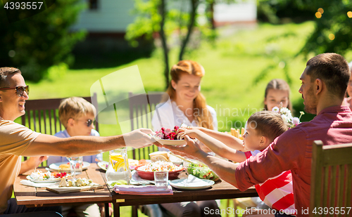 Image of happy family having dinner or summer garden party