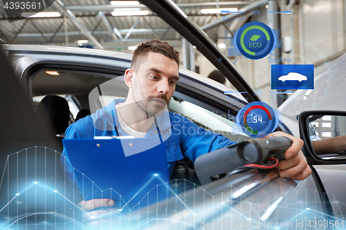 Image of mechanic man with diagnostic scanner at car shop