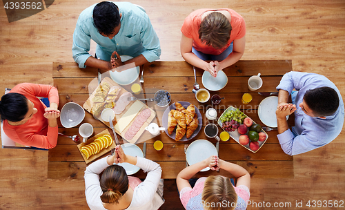 Image of group of people at table praying before meal