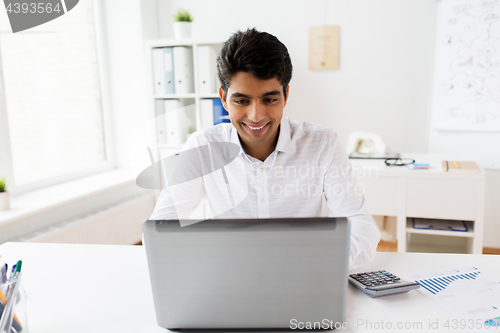 Image of businessman with laptop and papers at office