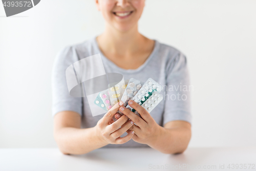 Image of happy woman holding packs of pills