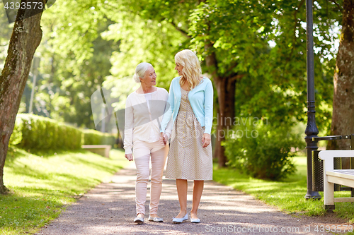Image of daughter with senior mother walking at summer park