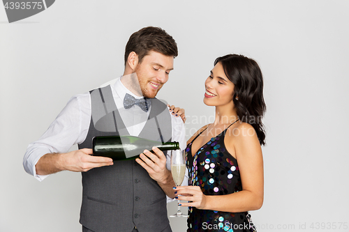 Image of happy couple with champagne and glass at party