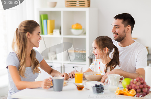 Image of happy family having breakfast at home