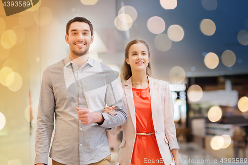 Image of happy young couple with shopping bags in mall