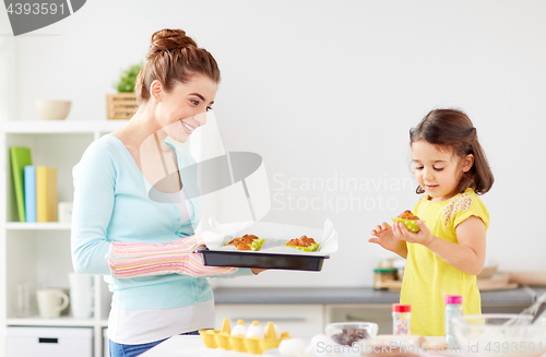 Image of mother and daughter baking muffins at home