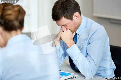 Image of upset or anxious businessman with report at office