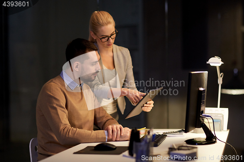 Image of business team with tablet pc late at office