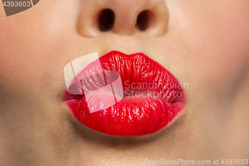 Image of woman lips with red lipstick making kiss 