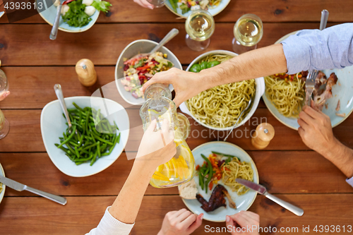 Image of people at table with food eating and drinking