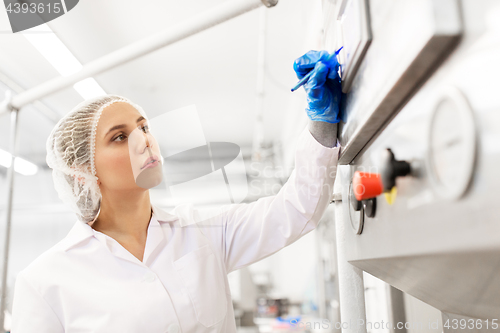 Image of woman programming computer at ice cream factory