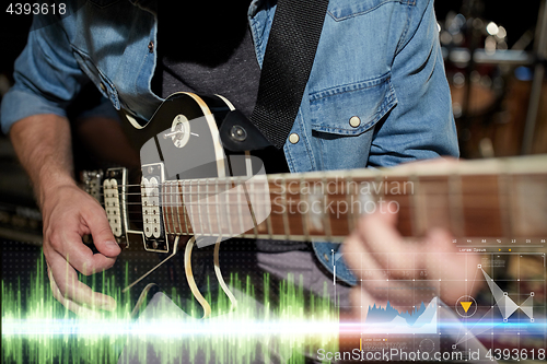 Image of close up of musician playing guitar at studio