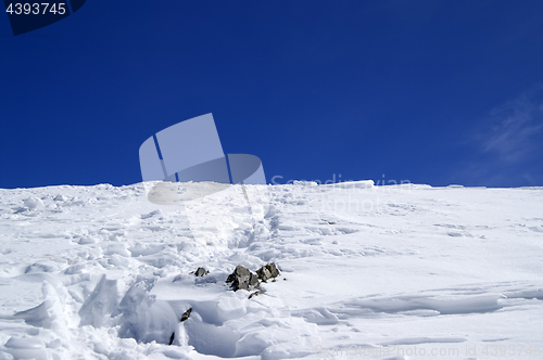 Image of Top of snowy mountains with footpath and blue sky