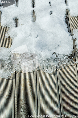 Image of Melting snow on a wooden terrace, close-up