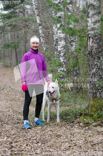 Image of Sporty woman with a dog in the park