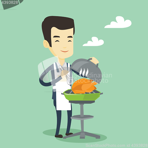 Image of Man cooking chicken on barbecue grill.