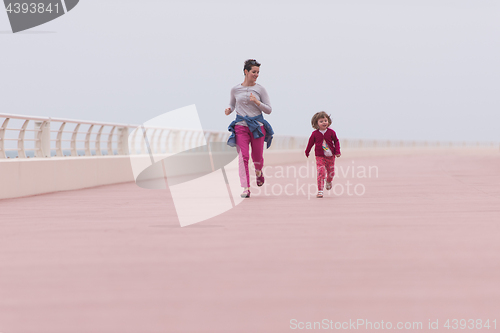 Image of mother and cute little girl on the promenade by the sea