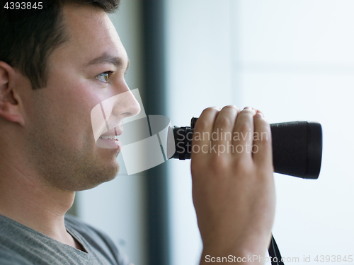 Image of man looking with binoculars