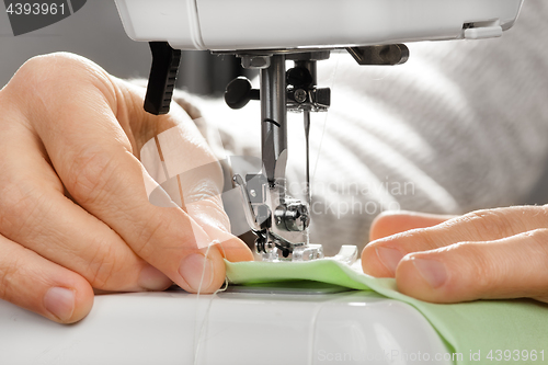 Image of hands working on the sewing machine