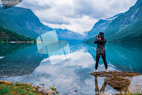 Image of Nature photographer tourist with camera shoots lovatnet lake Bea