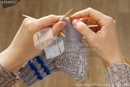 Image of woman hands knitting a sock